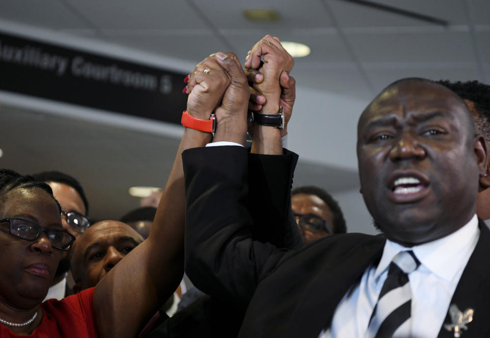 Botham Jean's mother, Allison Jean, and his father, Bertram Jean, raise their hands with their family attorneys Daryl Washington, Benjamin Crump and Lee Merritt after Guyger's murder conviction was delivered on Oct. 1, 2019. (Photo: Jeremy Lock / Reuters)