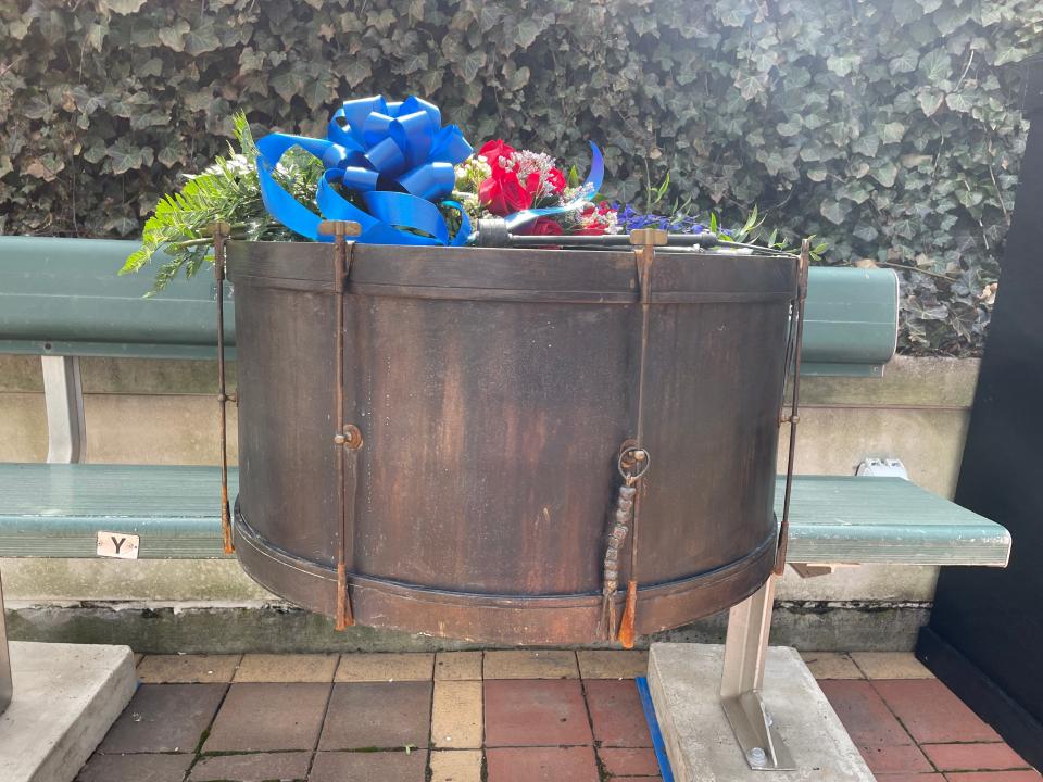 A brass-plated replica of John Adams' bass drum sits atop the iconic Guardians fan's bleacher seat in Heritage Park at Progressive Field.