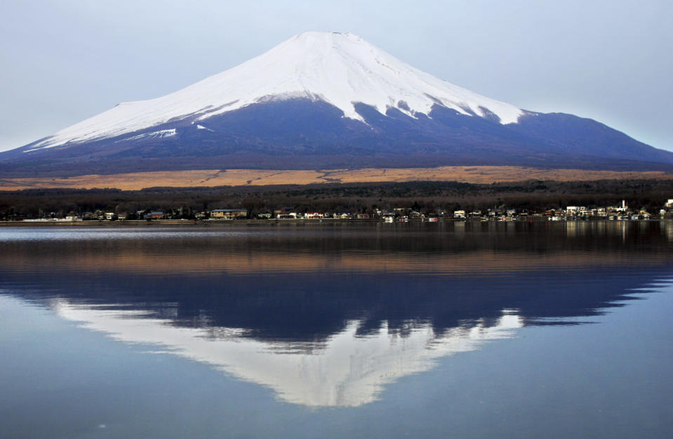 FILE - In this Sunday, April 15, 2007 file photo, Mount Fuji's peak in nearly symmetrical, snowcapped cone is reflected on the surface of Lake Yamanaka, west of Tokyo. Japan is cheering the selection of its most iconic landmark, Mount Fuji, as a World Heritage site. The 3,776-meter-tall mountain has deep cultural and religious meaning in Japan. (AP Photo/Shizuo Kambayashi)