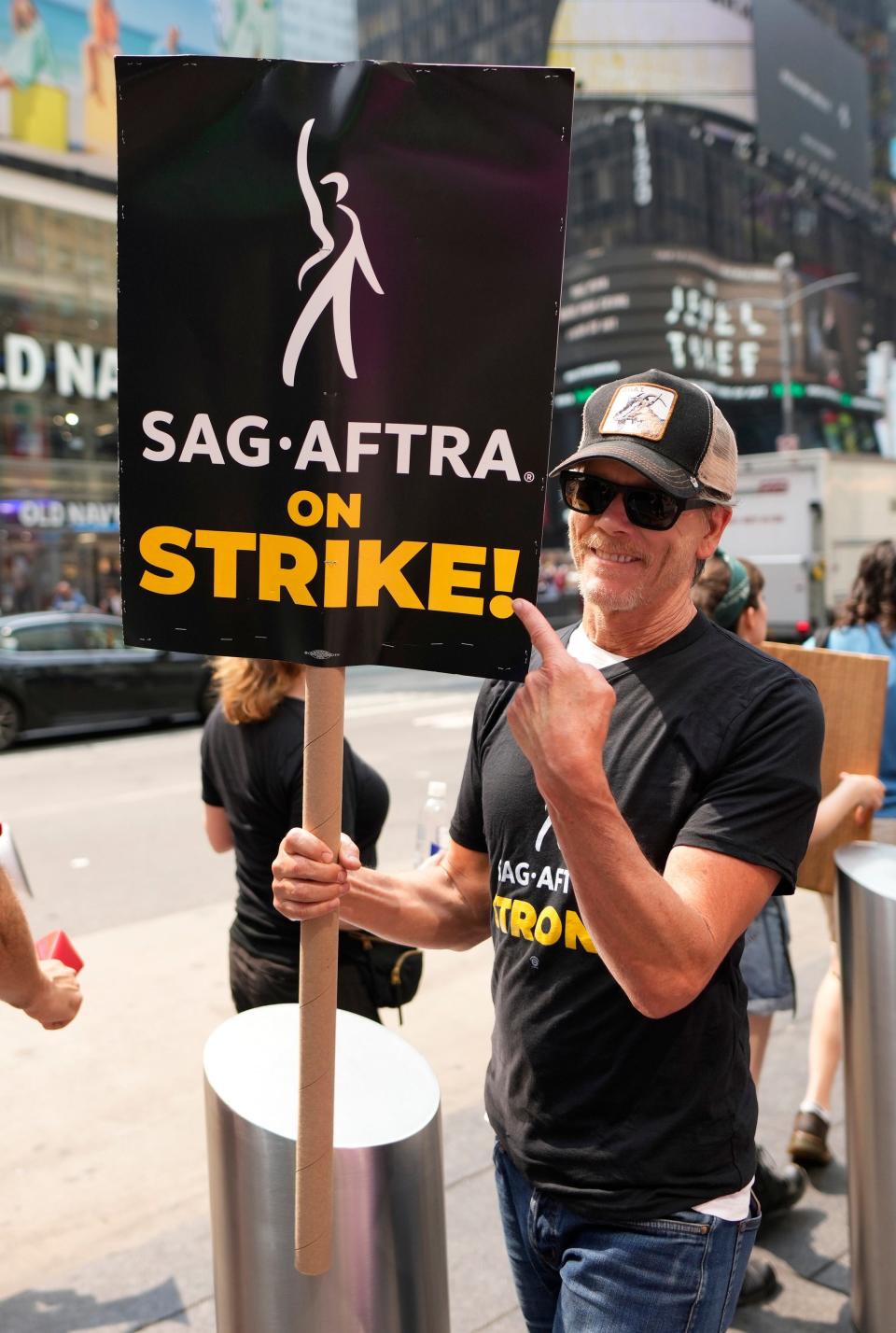 Actor Kevin Bacon carries a sign on a picket line outside Paramount in Times Square on Monday, July 17, 2023, in New York.