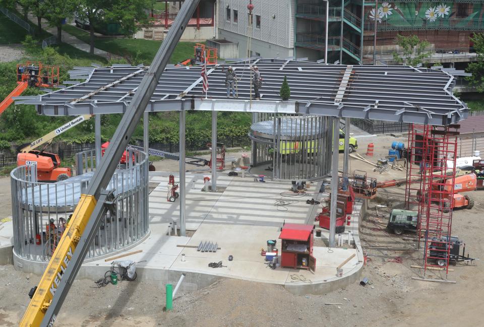 Construction workers atop the Maynard Performance Pavilion secure the final beam at Lock 3 Park on Tuesday, May 7, 2024, in Akron.