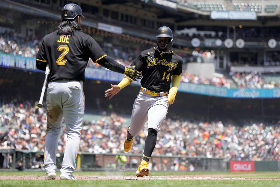Pittsburgh Pirates' Rodolfo Castro (14) is congratulated by Connor Joe (2) after both scored on a triple by Ke'Bryan Hayes during the third inning of a baseball game against the San Francisco Giants, Wednesday, May 31, 2023, in San Francisco. (AP Photo/Tony Avelar)