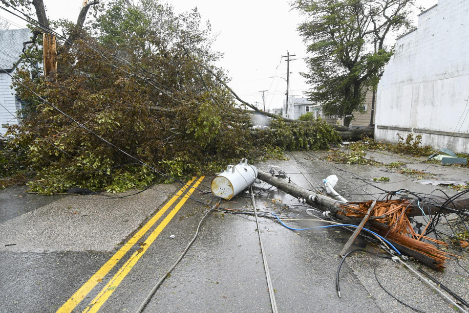 Downed power poles blocking part of a road in Glace Bay, Nova Scotia, on Sunday, Sept. 25, 2022. A day after post-tropical storm Fiona left a trail of destruction through Atlantic Canada and eastern Quebec, residents of a coastal town in western Newfoundland continued to pick through wreckage strewn across their community, easily the most damaged area in the region. (Vaughan Merchant/The Canadian Press via AP)