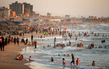 Palestinians dip in the Mediterranean Sea to cool off on a hot day in Gaza City July 19, 2016. REUTERS/Suhaib Salem