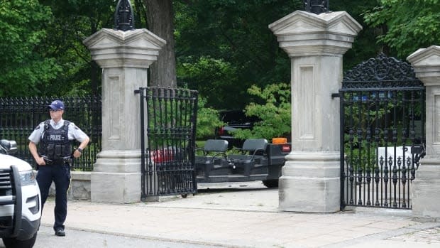 An RCMP officer stands outside the damaged gates of Rideau Hall on July 2, 2020. RCMP Commissioner Brenda Lucki told Public Safety Minister Bill Blair the police service needs to make changes to the way it deals with threats against politicians. (Francis Ferland/CBC - image credit)