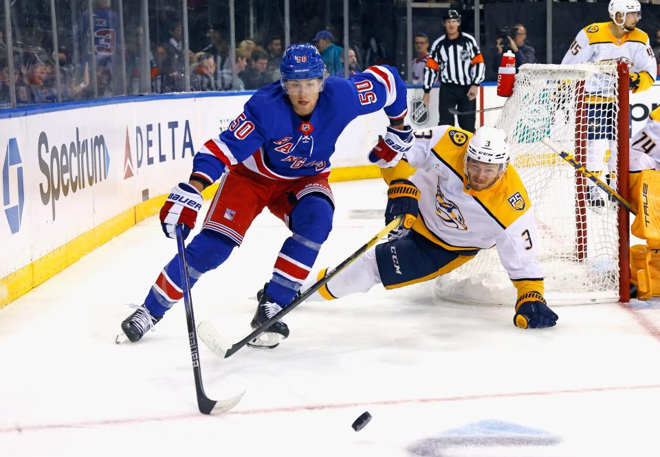 NEW YORK, NEW YORK - OCTOBER 19: Will Cuylle #50 of the New York Rangers carries the puck around Jeremy Lauzon #3 of the Nashville Predators during the second period at Madison Square Garden on October 19, 2023 in New York City.