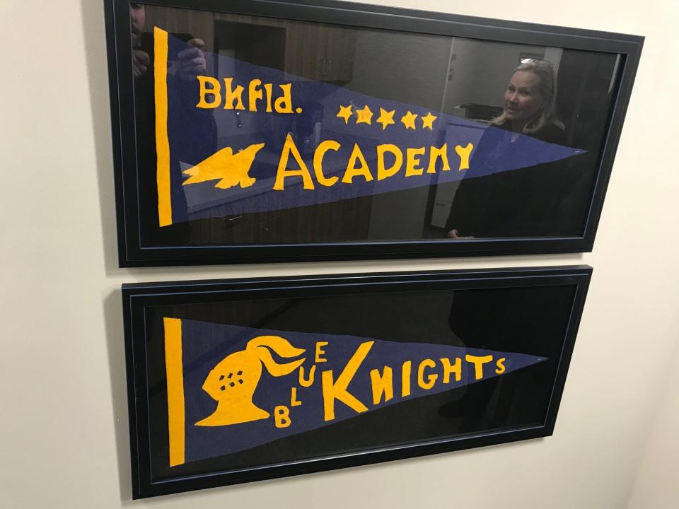 Old pennants showing Brookfield Academy's blue and gold colors and mascot, The Blue Knights, are shown here in a frame at Founder's Hall at the school.