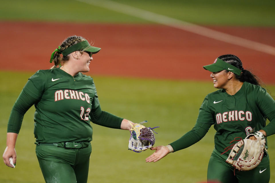 Mexico's Dallas Escobedo, left, and Victoria Vidales celebrate at the end of the second inning a softball game against Italy at the 2020 Summer Olympics, Sunday, July 25, 2021, in Yokohama, Japan. (AP Photo/Matt Slocum)