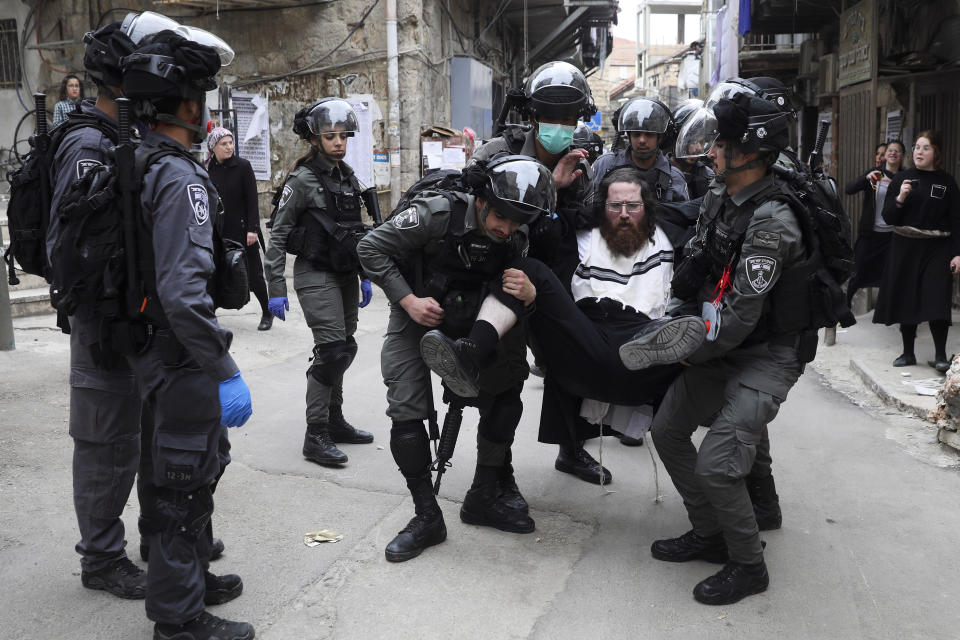 Israeli police arrest an ultra-Orthodox Jewish man during protest against government's measures to stop the spread of the coronavirus, in the Mea Shearim neighborhood of Jerusalem, on Monday, March 30, 2020. (AP Photo/Mahmoud Illean)