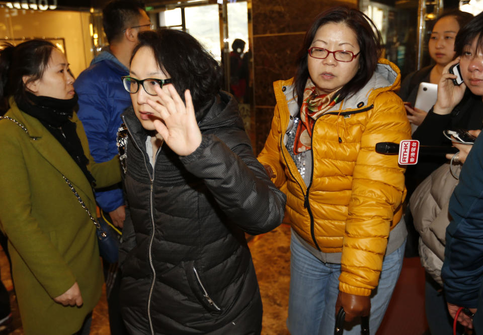 Unas mujeres chinas caminan a través del grupo de periodistas, mientras llegan al hotel preparado para los familiares de los pasajeros a bordo del avión desaparecido. La imagen fue tomada en Beijing, China este sábado 8 de enero de 2014.(AP Photo/Vincent Thian)