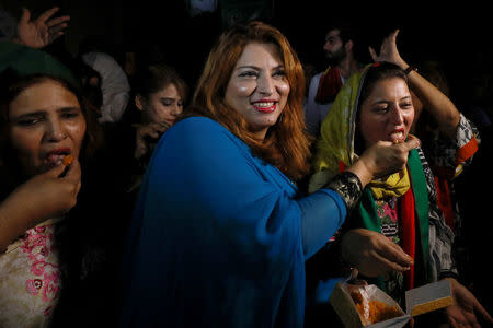 Supporters of cricket star-turned-politician Imran Khan, chairman of Pakistan Tehreek-e-Insaf (PTI), offer sweets to each other as they celebrate a day after the general election in Karachi, Pakistan July 26, 2018. REUTERS/Akhtar Soomro