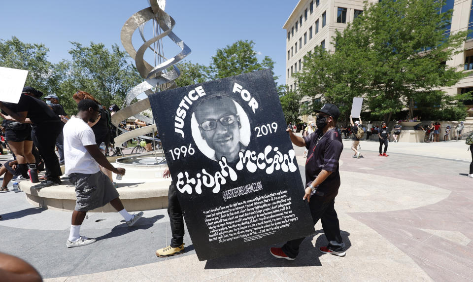 FILE - In this June 27, 2020, file photo, demonstrators carry a giant placard during a rally and march over the death of Elijah McClain outside the police department in Aurora, Colo. Prosecutors are expected to present opening statements Wednesday, Sept. 20, 2023, in the trial of Randy Roedema and Jason Rosenblatt on manslaughter, criminally negligent reckless homicide and assault charges. They, a third officer and two paramedics were indicted in 2021 by a state grand jury convened following an outcry over McClain’s death. (AP Photo/David Zalubowski, File)