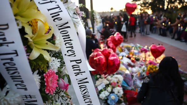 PHOTO: A message dedicated to victims, which is attached to a floral arrangement, is seen before the start of a candlelight vigil for victims of a deadly mass shooting at a ballroom dance studio on Jan. 24, 2023 in Monterey Park, California. (Mario Tama/Getty Images)