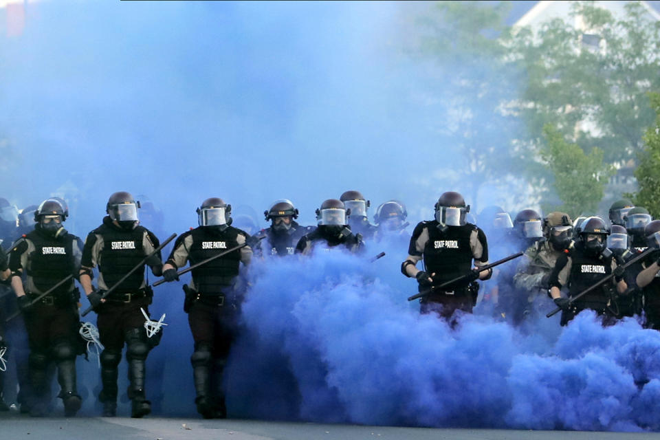 FILE - In this May 30, 2020, file photo, Minnesota State Police officers approach a crowd of protesters in Minneapolis. The Minnesota State Patrol purged e-mails and texts messages immediately after their response to protests in the wake of George Floyd’s death last summer, according to court testimony in a lawsuit that alleges the State Patrol targeted journalists during the unrest. (AP Photo/Julio Cortez, File)