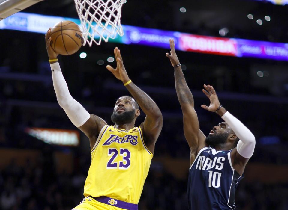 LeBron James goes up for a basket as Mavericks' Tim Hardaway Jr. defends.