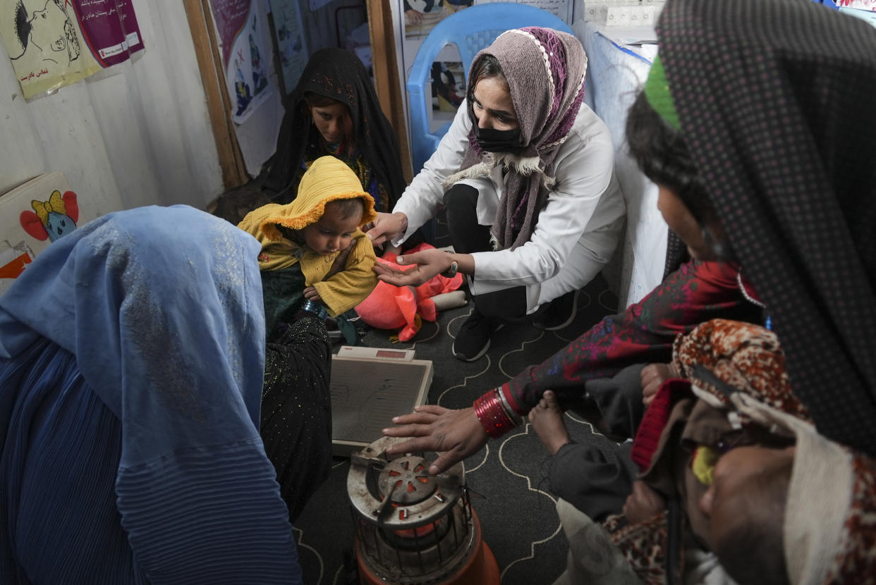 FILE - A nurse checks the weight of a child in a makeshift clinic organized by World Vision at a settlement near Herat, Afghanistan, Dec. 16, 2021. In a statement Tuesday, Jan. 11, 2022, the White House announced $308 million in additional humanitarian assistance for Afghanistan, offering new aid to the country as it edges toward a humanitarian crisis since the Taliban takeover nearly five months earlier. (AP Photo/Mstyslav Chernov, File)