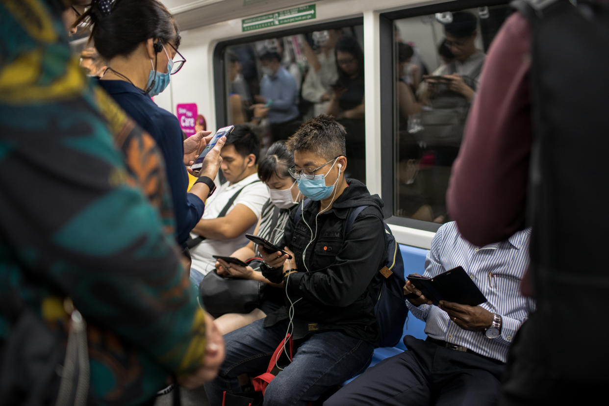 SINGAPORE - 2020/02/17: People wearing protective face masks on the train in Singapore. Singapore declared the COVID-19 outbreak as Code Orange on February 7, 2020 following the corona virus threat. (Photo by Maverick Asio/SOPA Images/LightRocket via Getty Images)