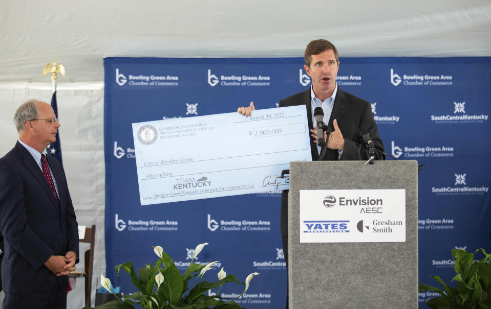 Gov. Andy Beshear, right, and Rep. Brett Guthrie, R-Bowling Green, left, present a check for $1 million to the Bowling Green Fire Department for the construction of a Kentucky Transpark fire station at the groundbreaking ceremony for the new $2 billion, 3-million-square-foot Envision AESC electric vehicle battery technology gigafactory to be constructed in the Kentucky Transpark in Bowling Green, Ky., Tuesday, Aug. 30, 2022. The Envision AESC gigafactory at Bowling Green in south-central Kentucky will produce battery cells and modules that will power electric vehicles produced by multiple automakers. (Grace Ramey/Daily News via AP)