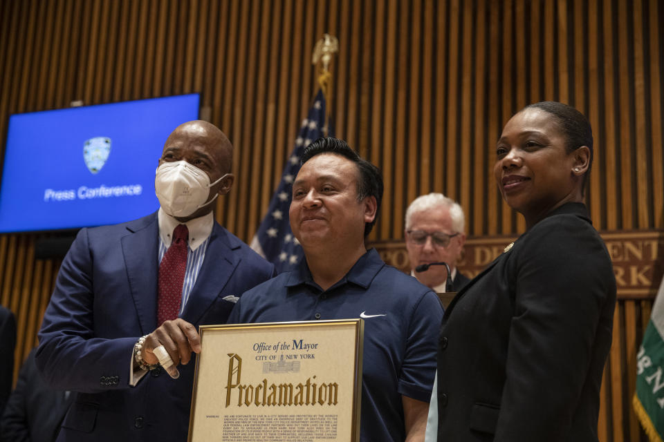 El alcalde de la ciudad de Nueva York, Eric Adams, y la comisionada de la policía, Keechant Sewell, le rinden homenaje a Francisco Puebla, quien ayudó en la captura del sospechoso del tiroteo en el metro de Brooklyn, en Nueva York, el 20 de abril de 2022. (Victor J. Blue/The New York Times)
