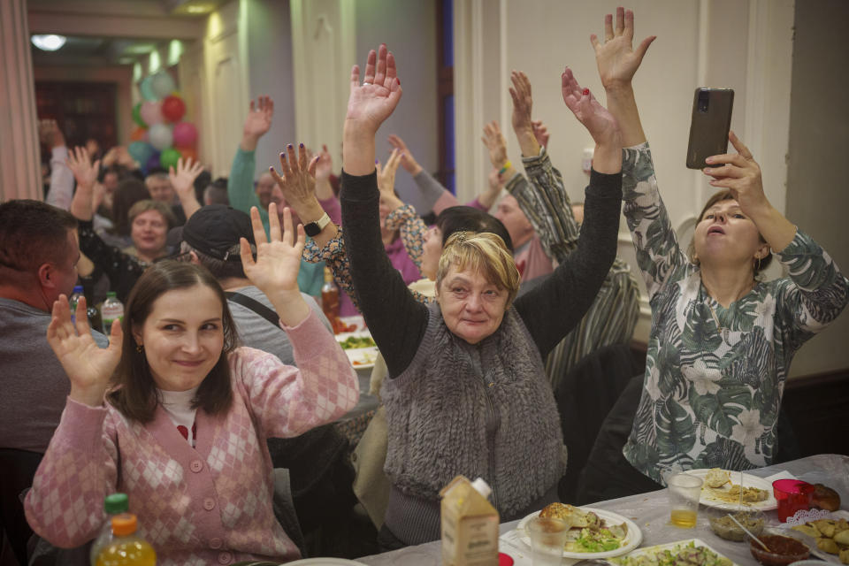 Women of the Ukrainian Jewish community raise their hands to the rhythm of music during Purim celebrations and a festive meal at the Great Choral Synagogue in Kyiv, Ukraine, Sunday, March 24, 2024. (AP Photo/Vadim Ghirda)