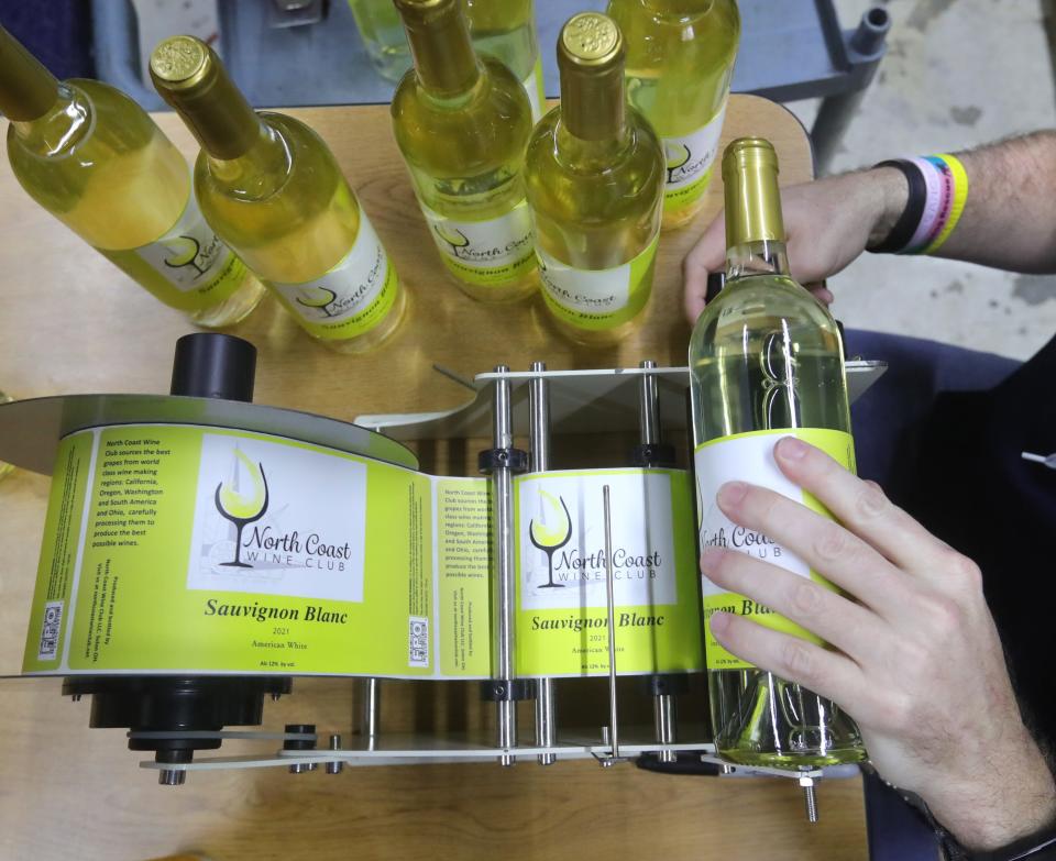 North Coast Wine Club member Paul Chudzinski attaches labels to freshly bottled sauvignon blanc.