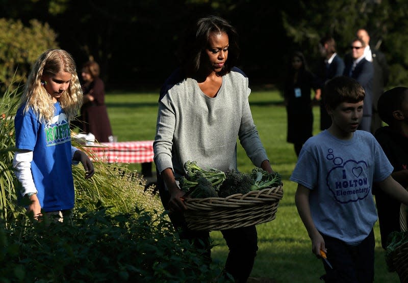 Michelle Obama carries a basket of broccoli