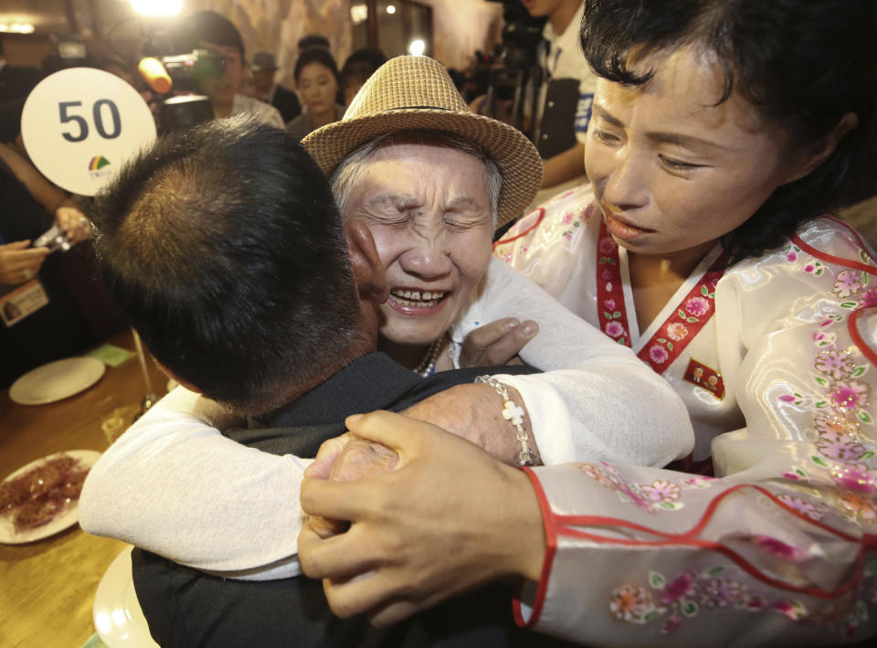 South Korean Lee Keum-seom, 92, center, hugs her North Korean son Ri Sang Chol, 71, left, with Kim Ok Hui, daughter-in-law of Ri Sang Chol during the Separated Family Reunion Meeting at the Diamond Mountain resort in North Korea, Monday, Aug. 20, 2018. Dozens of elderly South Koreans crossed the heavily fortified border into North Korea on Monday for heart-wrenching meetings with relatives most haven't seen since they were separated by the turmoil of the Korean War. (Lee Ji-eun/Yonhap via AP)