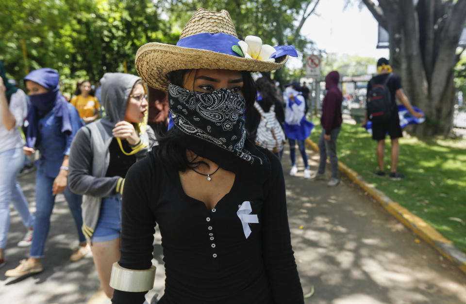 A student hiding her identify for fear of being identified and later attacked by security forces or government supporters attends a protest demanding the release of all political prisoners, on the last day of a 90-day period for releasing such prisoners as agreed to during negotiations between the government and opposition, on the Central American University (UCA) campus where security forces legally cannot enter in Managua, Nicaragua, Tuesday, June 18, 2019. Nicaragua's government said Tuesday that it has released all prisoners detained in relation to 2018 anti-government protests, though the opposition maintains that more than 80 people it considers political prisoners are still in custody. (AP Photo/Alfredo Zuniga)