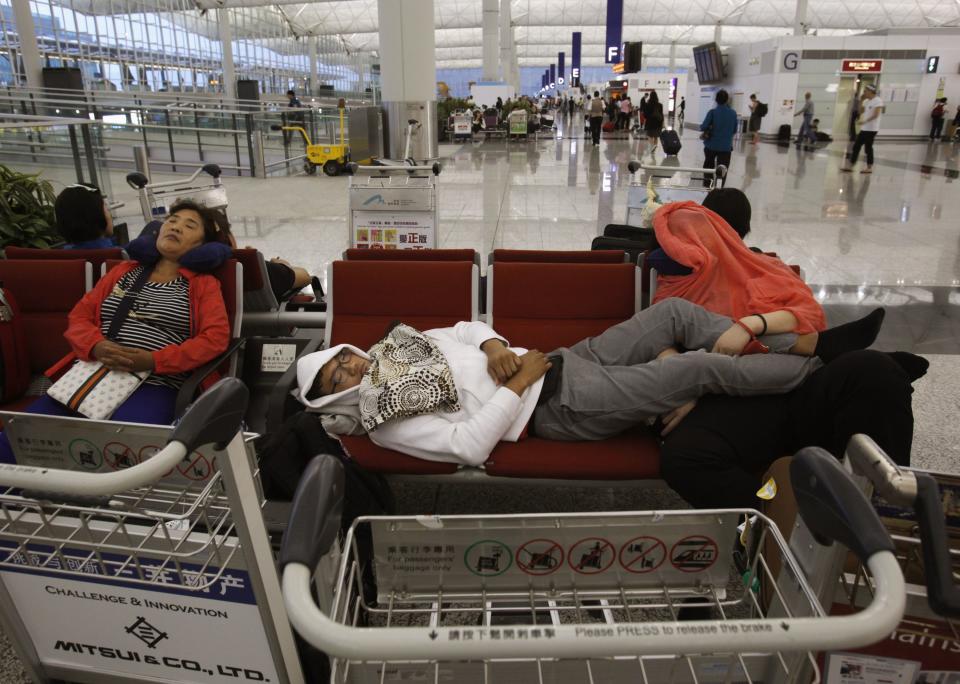 Passengers whose flights are cancelled in anticipation of typhoon Usagi, rest at Hong Kong Airport September 22, 2013. Hong Kong was bracing on Sunday for this year's most powerful typhoon, with government meteorologists warning of severe flooding created by a double whammy of powerful winds and exceptionally high tides. (REUTERS/Bobby Yip)