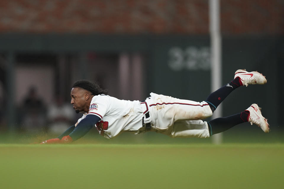 Atlanta Braves' Ozzie Albies dives to steal second base during the ninth inning in Game 1 of baseball's National League Championship Series against the Los Angeles Dodgers Saturday, Oct. 16, 2021, in Atlanta. The Braves defeated the Dodgers 3-2 to take game 1. (AP Photo/Brynn Anderson)