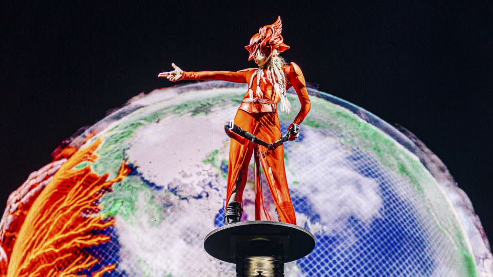 Grimes accompanied DJ Anyma at the Sahara Stage during weekend one, wearing a sheer red Dion Lee maxi skirt and warrior helmet. - Matt Winkelmeyer/Getty Images for Coachella