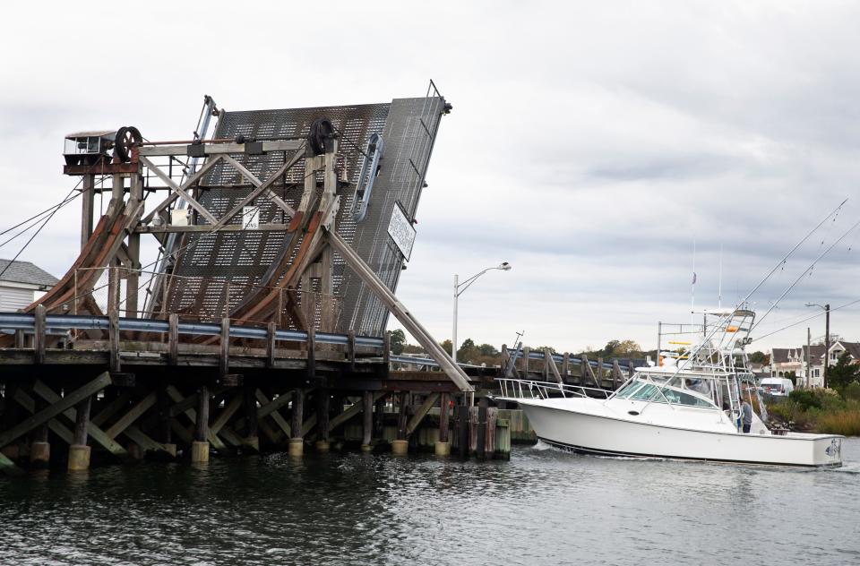 A fishing vessel passes through the open bridge. Monmouth County has been researching how to replace Glimmer Glass Bridge since the mid 1990s. After more than 35 years of trying, it hasn't happened, it could be a while even though there's a proposed replacement plan.                                                                             Manasquan, NJSaturday, October 23, 2021  