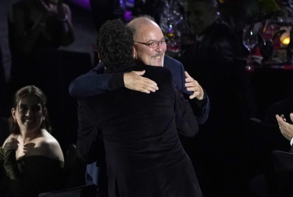 Carlos Vives, de espaldas, abraza a Rubén Blades tras su actuación en la gala en honor al artista y activista panameño como Persona del Año de la Academia Latina de la Grabación, el miércoles 17 de noviembre de 2021 en el hotel y casino Mandalay Bay en Las Vegas. (AP Foto/Chris Pizzello)