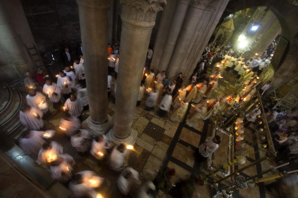 Christian clergymen hold candles during the Easter Sunday procession at the Church of the Holy Sepulchre, traditionally believed by many to be the site of the crucifixion and burial of Jesus Christ, in Jerusalem's Old City, Sunday, April 20, 2014. Millions of Christians around the world are celebrating Easter commemorating the day when according to Christian tradition Jesus was resurrected in Jerusalem two millennia ago. (AP Photo/Sebastian Scheiner)