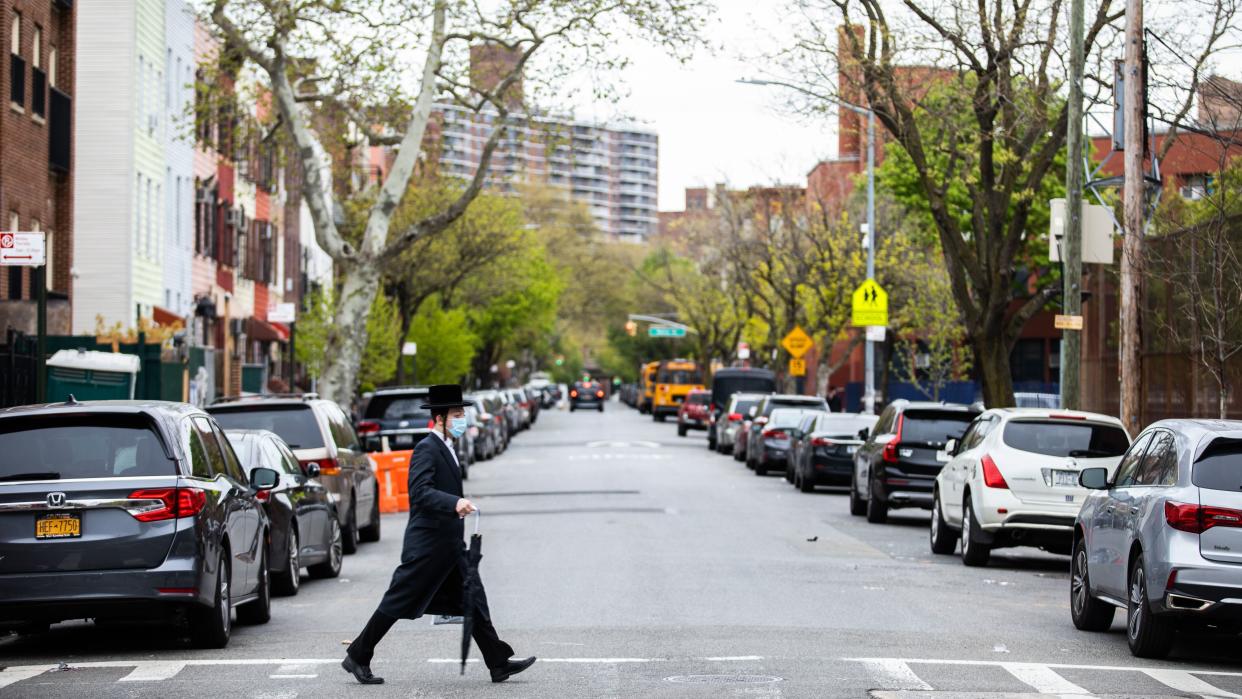 A man crosses the street in the Williamsburg neighborhood of Brooklyn, New York, on April 29. (Photo: Demetrius Freeman for HuffPost)