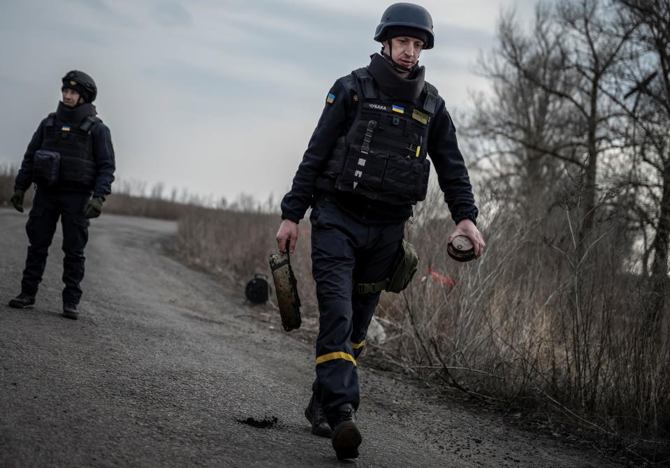 A sapper of the State Emergency Service carries an anti-tank mine as he inspects an area for mines and unexploded shells, as Russia's attack on Ukraine continues, in Kharkiv region, Ukraine March 21, 2023.
