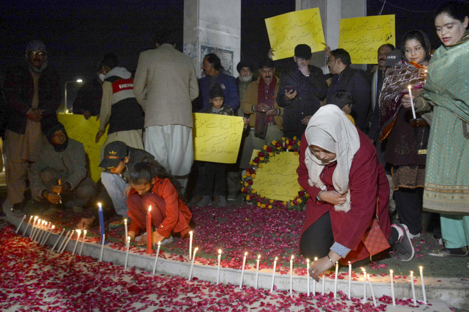 Children light candle as they with other take part in a candle light vigil for the victims of Monday's suicide bombing, called by a civil society group, in Quetta, Pakistan, Feb. 2, 2023. A suicide bomber who killed 101 people at a mosque in northwest Pakistan this week had disguised himself in a police uniform and did not raise suspicion among guards, the provincial police chief said on Thursday. (AP Photo/Arshad Butt)