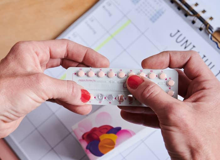 A person holding a pack of birth control