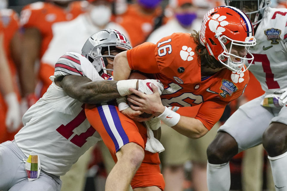 Clemson quarterback Trevor Lawrence is tackled by Ohio State defensive end Tyreke Smith during the second half of the Sugar Bowl NCAA college football game Friday, Jan. 1, 2021, in New Orleans. (AP Photo/John Bazemore)