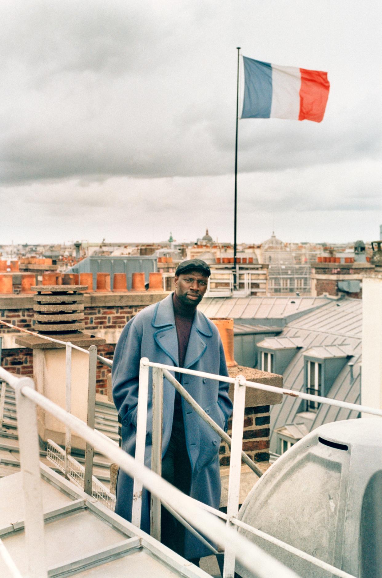 On Top of the World
Sy, photographed in Paris, is easily the most beloved actor in France—even before his breakout role as Assane Diop in Lupin. Dior Men coat. Dolce & Gabbana sweater and cap. Boss pants. Hair, JAYR; makeup, Angloma. Fashion Editor: Michael Philouze.