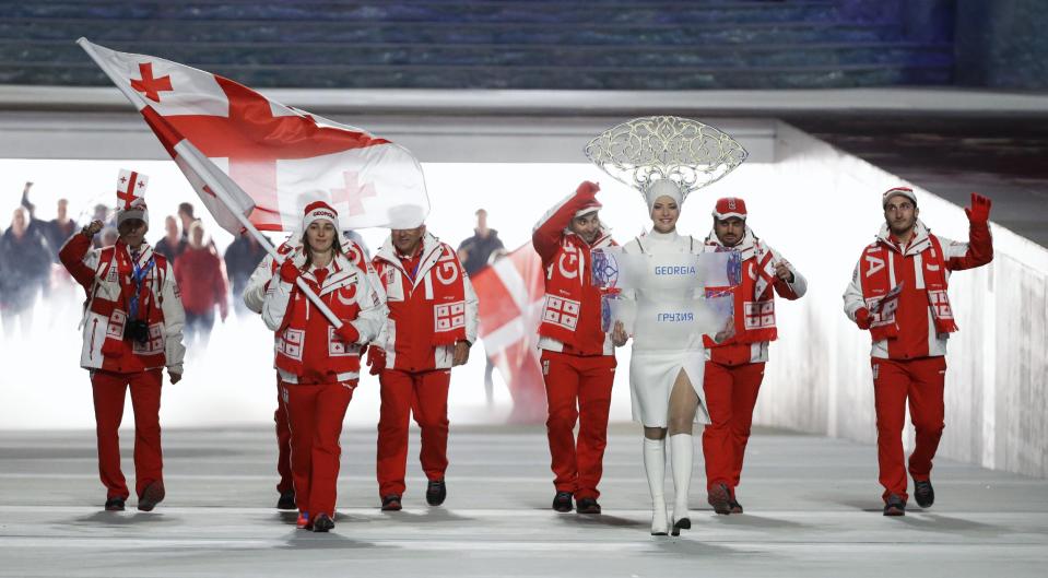 Nino Tsiklauri of Georgia carries the national flag as she leads the team during the opening ceremony of the 2014 Winter Olympics in Sochi, Russia, Friday, Feb. 7, 2014. (AP Photo/Mark Humphrey)