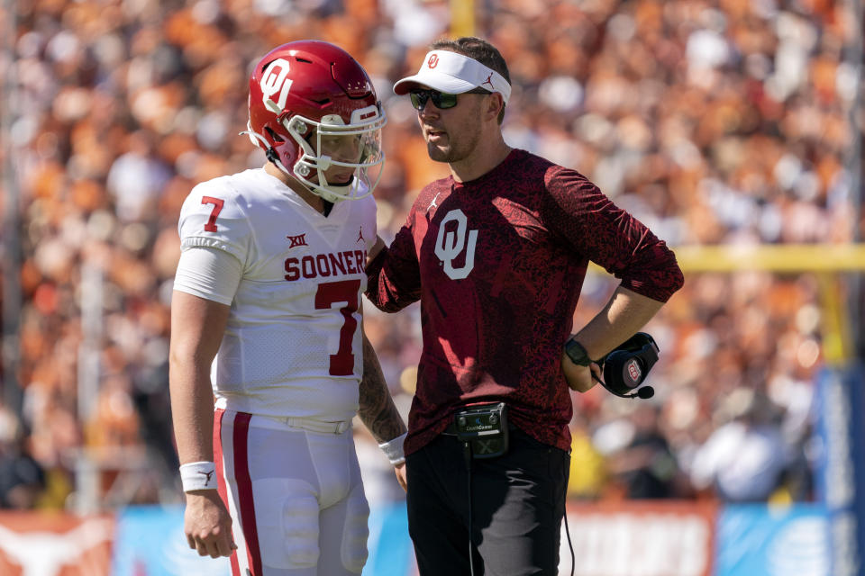 Oklahoma head coach Lincoln Riley talks to quarterback Spencer Rattler before sending Rattler in for a two-point conversion during the second half of an NCAA college football game against Texas at the Cotton Bowl, Saturday, Oct. 9, 2021, in Dallas. (AP Photo/Jeffrey McWhorter)