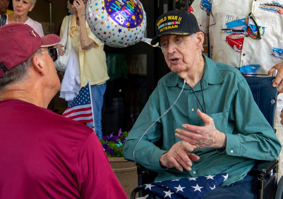 Rolling Thunder member Bryan Bredhold, left, chats with U.S. Army veteran Thurman Carnal, right, about his time during World War II after presenting him with a flag and pin on his 107th birthday in Evansville, Ind., Thursday, July 6, 2023.