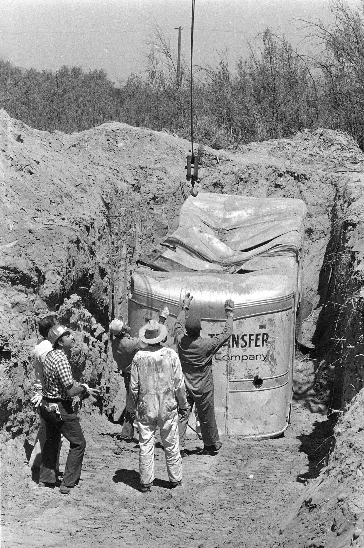 FILE - Officials remove a truck buried at a rock quarry in Livermore, Calif., in which 26 Chowchilla school children and their bus driver, Ed Ray, were held captive on July 20, 1976. California parole commissioners have recommended parole for the last of three men convicted of hijacking the school bus full of children for $5 million ransom in 1976. The two commissioners acted Friday, March 25, 2022, in the case of 70-year-old Frederick Woods. (AP Photo/James Palmer, File)
