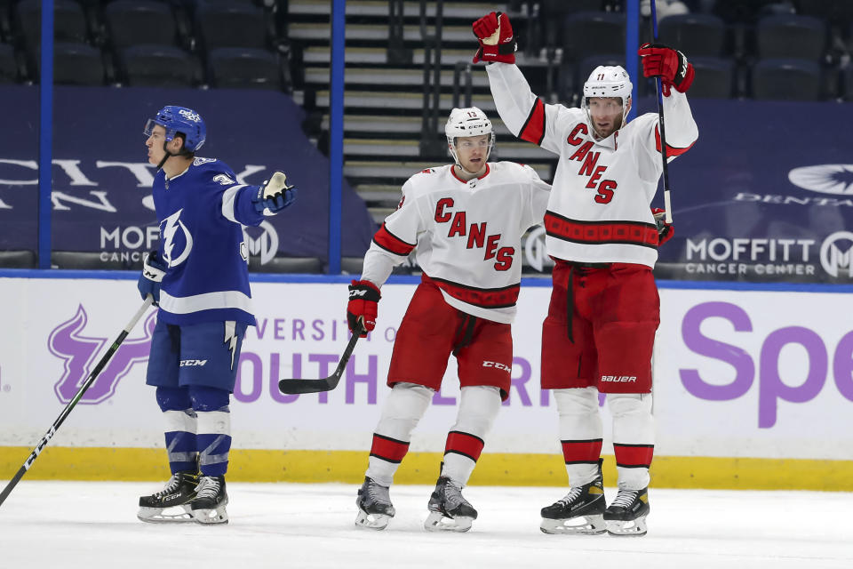 Carolina Hurricanes' Jordan Staal, right, celebrates his goal with Warren Foegele as Tampa Bay Lightning's Yanni Gourde reacts during the second period of an NHL hockey game Tuesday, April 20, 2021, in Tampa, Fla. (AP Photo/Mike Carlson)