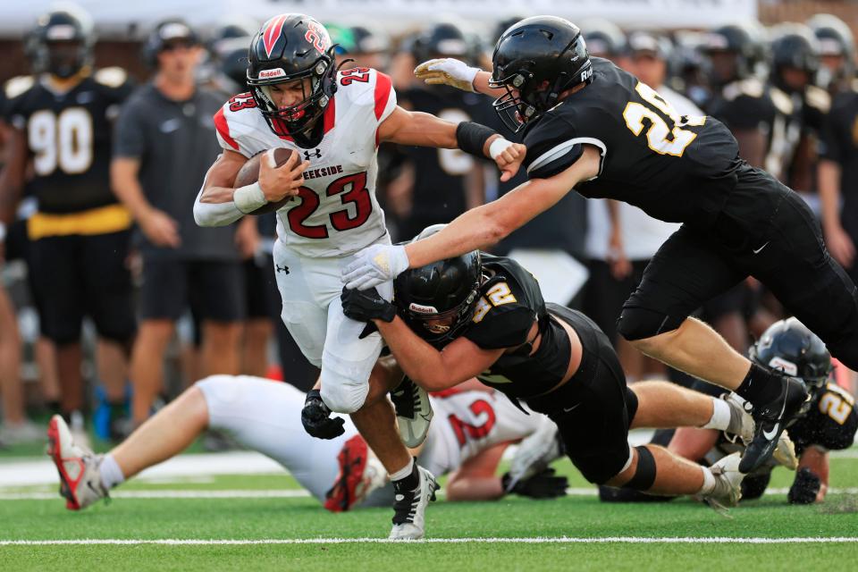 Creekside's Harrison Garrido (23) tries to elude Richmond Hill tacklers in a Sept. 9 game.