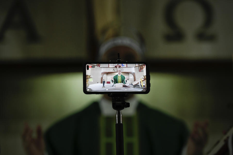 El sacerdote Honegger Molina transmite en vivo por las redes sociales una misa en la parroquia Anunciación del Señor, en Caracas, Venezuela, el domingo 4 de octubre de 2020, en medio de la pandemia del coronavirus. (AP Foto/Matias Delacroix)