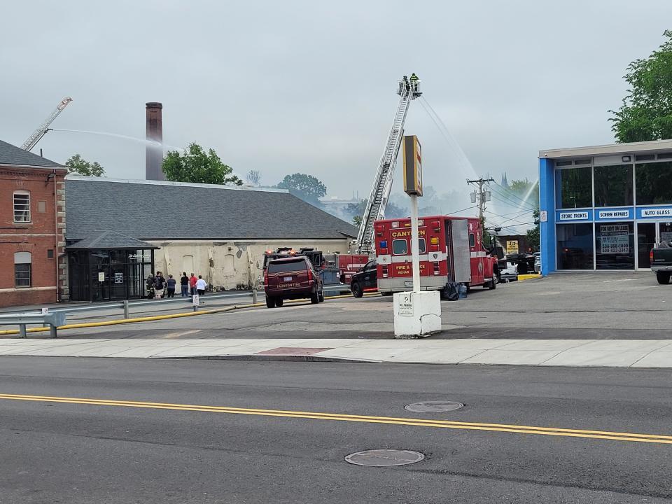 Crews work to put out a 5-alarm fire at 4 Spring Lane in Taunton on Saturday, May 28, 2022. Flames could still be seen coming through the roof of J&J Diecast Collectibles.