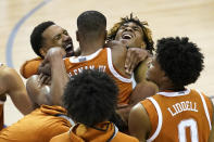 Texas guard Matt Coleman III (2) is hugged by teammates after Texas beat North Carolina 69-67 to win the NCAA college basketball game for the championship of the Maui Invitational, Wednesday, Dec. 2, 2020, in Asheville, N.C. Coleman was the MVP with the winning basket and high score of 22 points. (AP Photo/Kathy Kmonicek)