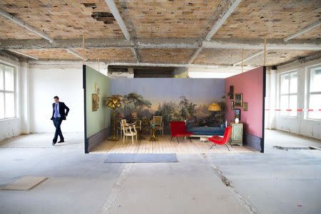 George Darbishire of Ziegert Property walks past a 20 square metre model room in a floor of the Metropolis Park development that will be turned into a loft in Berlin June 26, 2014. EUTERS/Thomas Peter